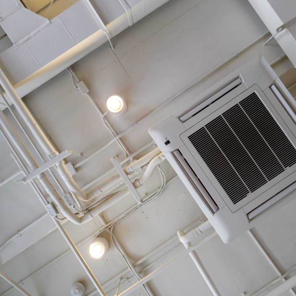 White Industrial air conditioner cooling pipe with plumbing at ceiling. Ventilation system ceiling air duct.
